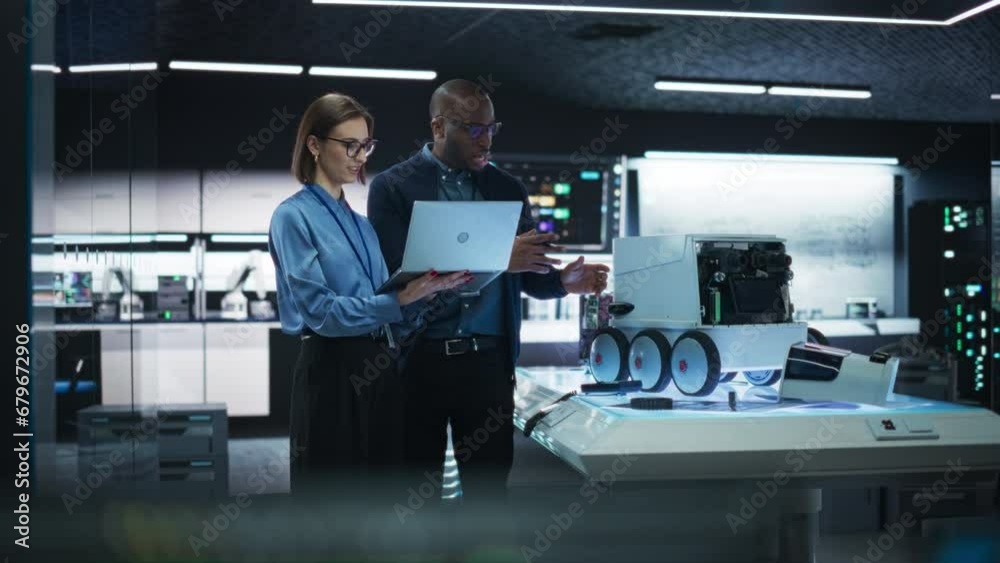 Poster Portrait of a Team of Two Engineers Collaborating on Developing a Robot for Deliveries in a Manufacturing Facility. Colleagues Analysing Data Using Laptop Computer and Brainstorming for a Project