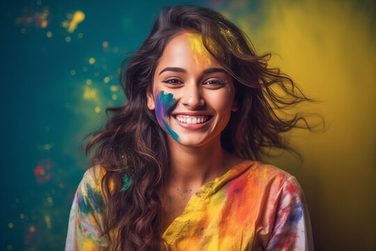 Portrait of Indian happy young woman with multi colored powder paint o face. Concept of Holi festival of colors in India