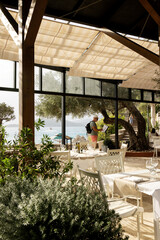 A restaurant located on the seashore, a tourist reads the menu at the entrance