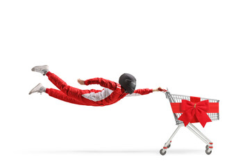 Car racer in a red suit and black helmet flying with a shopping cart tied with red ribbon bow
