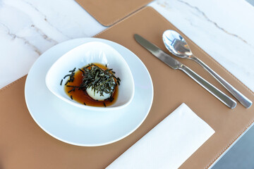 Onsen eggs soaked in sauce in a white bowl Sprinkle the top with shredded seaweed on the hotel's...
