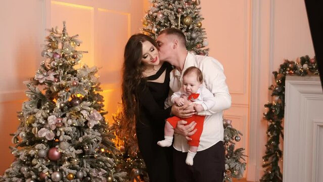 Concept of happy memories in childhood, Christas tree decoration, balls, garland light. Family with newborn baby celebrate New Year winter holiday together at home