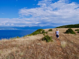 Fototapeta na wymiar Couple hiking on Lin peninsula, Albania, Lake Ohrid in the background.