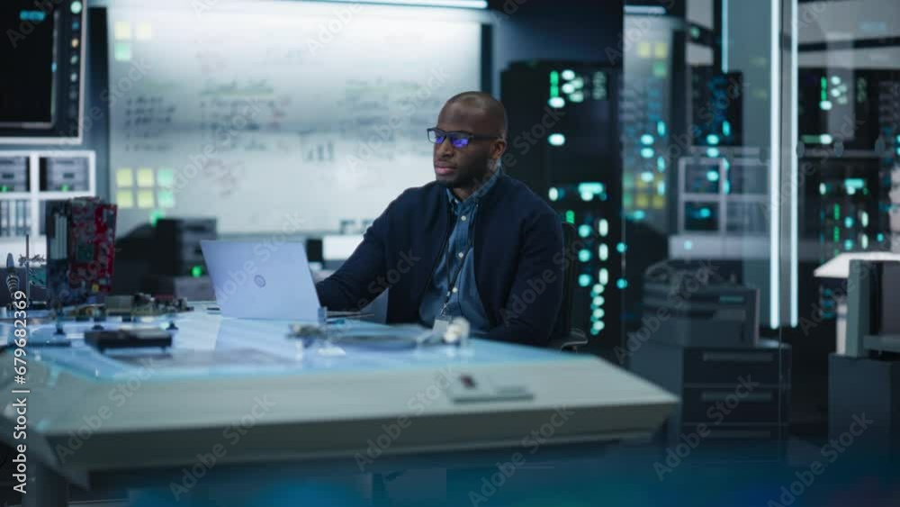 Poster portrait of male african-american specialist using laptop computer to improve electronic circuit boa