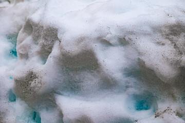 close-up of thick snow. snow with a turquoise reflection. pile of mountain snow. background of a pile of snow