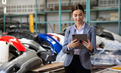 Motor insurance. Car insurance agent examining car by Claim form digital tablet computer in garage....
