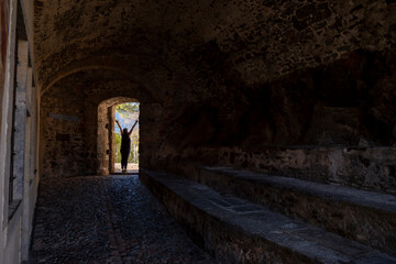 Woman with Arms Outstretched in Church Sant' Antonio Abate with Sunlight in Morcote, Ticino in...