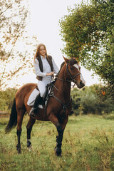 Obraz premium A woman jockey trains her horse to follow commands. The horse raises its leg at the command of the rider.