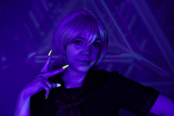 anime style woman with blonde wig and fluorescent manicure showing victory sign in blue neon light