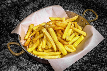 Close-up of Perfectly Served French Fries in a Stylish Frying Pan.  Ideal for menus, food blogs, or any design endeavor seeking to capture the essence of indulgent comfort food.