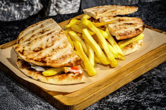Mediterranean Fusion Delight – Close-up of Skepasti greek club sandwich with Crispy French Fries.  Mediterranean flair to your culinary designs, menus, or food-related content