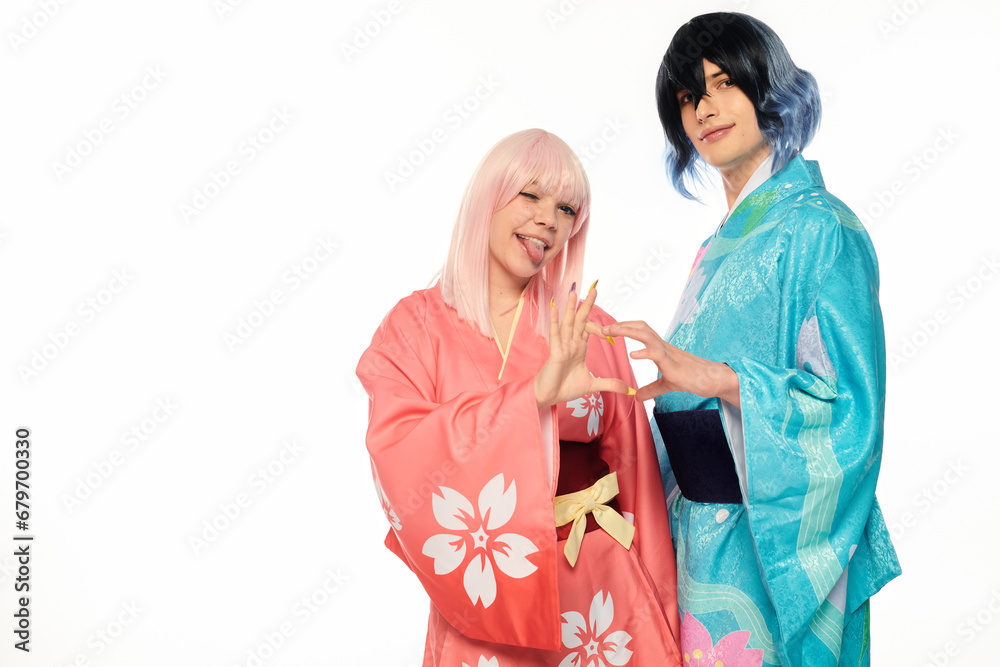 Wall mural anime style woman sticking out tongue and showing heart sigh with extravagant man in kimono on white