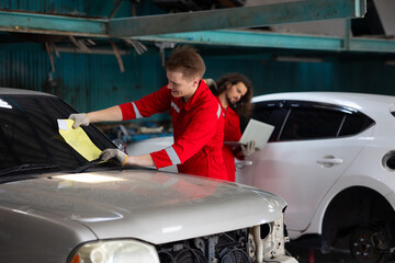 Professional teamwork man mechanic working repairs car in garage. Car maintenance and auto service garage concept