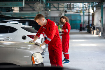 Professional teamwork man mechanic working repairs car in garage. Car maintenance and auto service garage concept