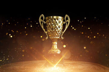Image of trophy over wooden table and dark background, with abstract shiny lights