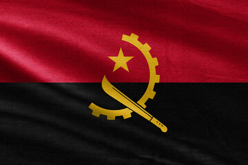 Close up of the Angola flag. Angola flag of background. Flag of Angolan. Angola flag with big folds waving close up under the studio light indoors. The official symbols and colors in fabric banner