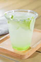 iced green tea with lime on wood table - soft focus with vintage film filter