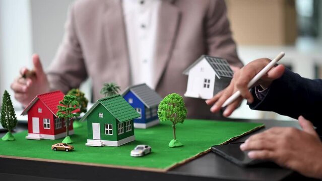 Balancing the property sector The real estate agent is explaining the house style to see the house design and the purchase agreement