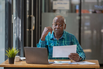 Senior black man in casual clothes holding and focus on document in hands, Verifying report,...