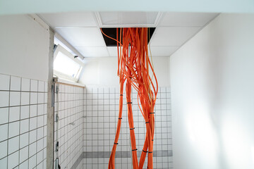 orange network cables run bundled under the ceiling.