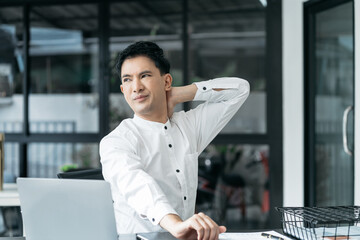 Male businessman is doing a stretchy posture due to sitting in the office for too long, office syndrome concept.