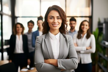 Fototapeta premium Smiling confident business leader looking at camera and standing in an office at team meeting.