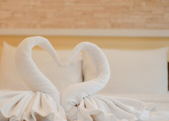 White swan-shaped towels on the bed to welcome new guests in a luxury hotel at a seaside resort