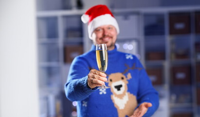 Bearded smiling man wearing warm blue sweater with traditional deer hold arm champagne goblet rising toast coming 2018 year with glowing garland background concept closeup
