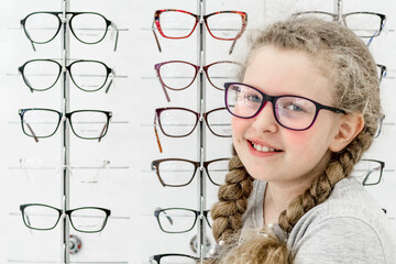 Cheerful girl with glasses on the background of a rows of spectacles. A child, attractive teenager...