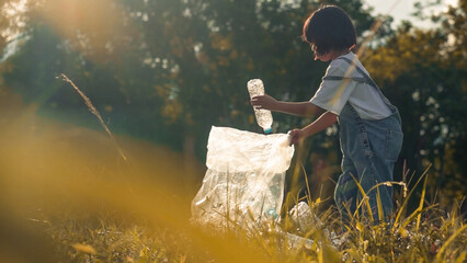 Kid Girl  collection plastic garbage in nature. kid picking up trash in park.