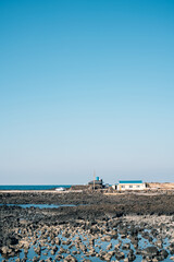 Obraz premium Stone beach and house in Jeju Island, Korea