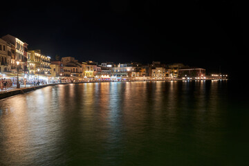 Fototapeta na wymiar Tourists, taverns and houses at night in the port of Chania city, Greece