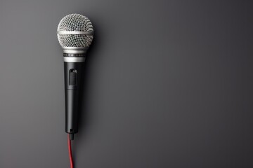 Microphone and cable arranged against a simple minimalist background.