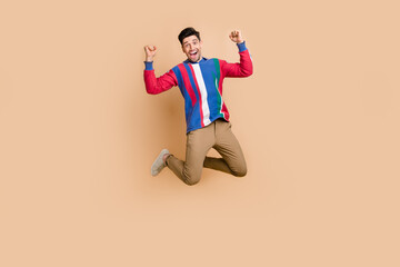 Fototapeta na wymiar Full length body photo of jumping trampoline funky sportive businessman celebrating finance plan done isolated on beige color background