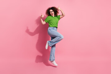 Full length photo of optimistic glad good mood girl wear stylish clothes fly air thumb up empty space isolated on pink color background