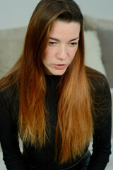 Young pretty girl with long red hair in a black shirt