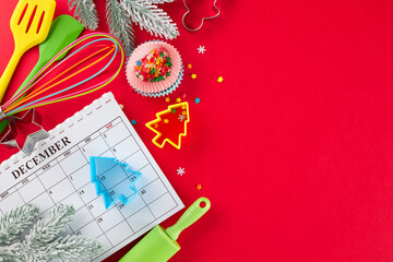 Preparing for making Christmas sweets. Top view photo of calendar, candies, frost-kissed fir branches, baking equipment, baking molds, stars on red background with promo zone