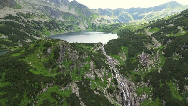 Embracing sunrise above misty mountains and Morskie Oko lake in Tatra. Soaring over clouds, witnessing lush scenery and twin lakes in a majestic mountain vista. Zakopane, Poland. High Tatra Mountains