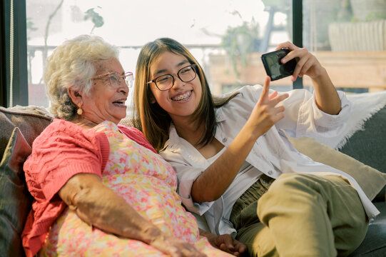 The granddaughter takes a self-portrait with her grandmother for her social networks.