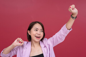 A jubilant short-haired young asian woman feels triumphant. Arms raised in the air. Studio shot...