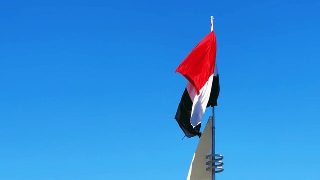 Hurghada, Egypt - December 2022: View of the flag of the country of Egypt. The flag flutters in the wind on the Mediterranean coast. 4K