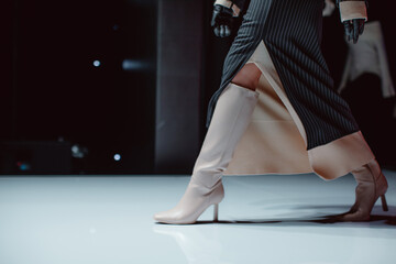 Black long skirt and beige high heels. Fashion model walking runway fashion show - obrazy, fototapety, plakaty