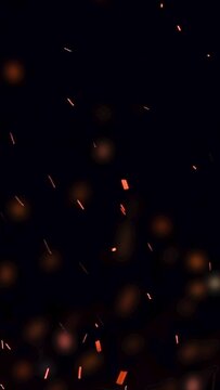 ultra slow motion high speed shot of fire flames and glowing ash particles on black background - vertical video for reel and story