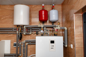 A modern air heat pump installed in the home's boiler room, visible plastic pipes and valves. - obrazy, fototapety, plakaty