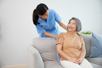 caregiver or nursing home helping and talking with senior woman