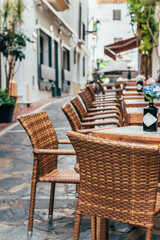 Fototapeta na wymiar Empty tables at streets of city of Marbella in Costa del Sol, Spain. The Old Town and iconic streets in Marbella, Spain, and major tourist attractions with shops and bars at city centre