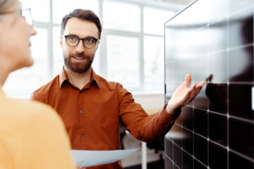 Business people, engineers working with solar panel in modern office. Smiling confident colleagues...