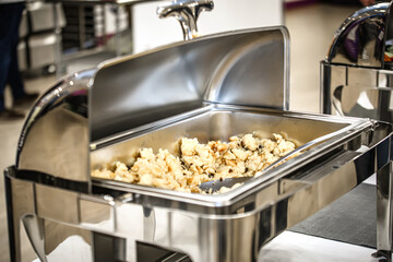 Close up of a stainless steel catering buffet in a hotel restaurant.