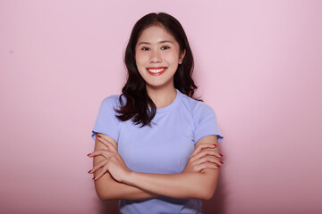Fototapeta premium Portrait of a friendly young woman smiling happily, Portrait of a beautiful young woman in a light pink background, happy and smile, posting in stand position.