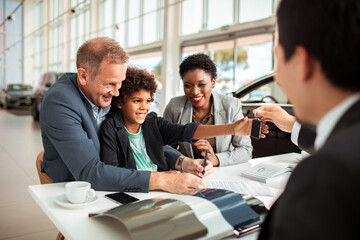 Family at Car Dealership Receiving Keys to New Vehicle